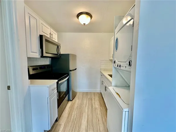 a kitchen with a sink a microwave and cabinets