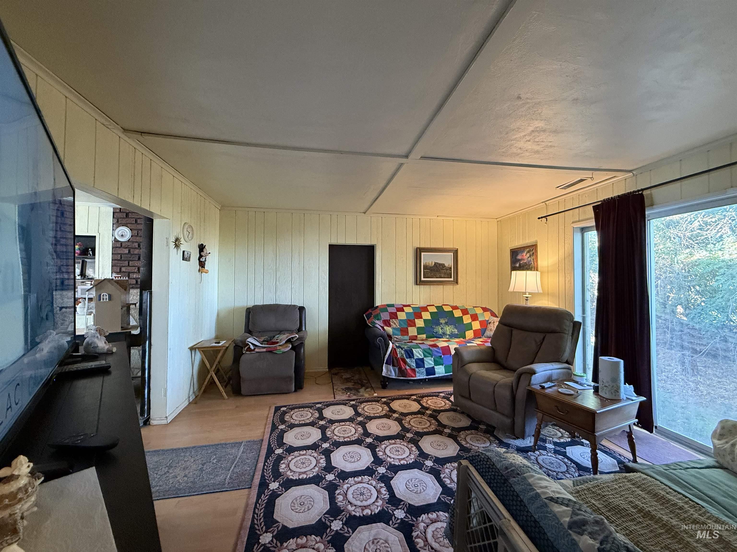 19241 West Homedale Road Caldwell, ID 83607 - Photo 19 of 35 Living room with wood walls and light wood-type flooring