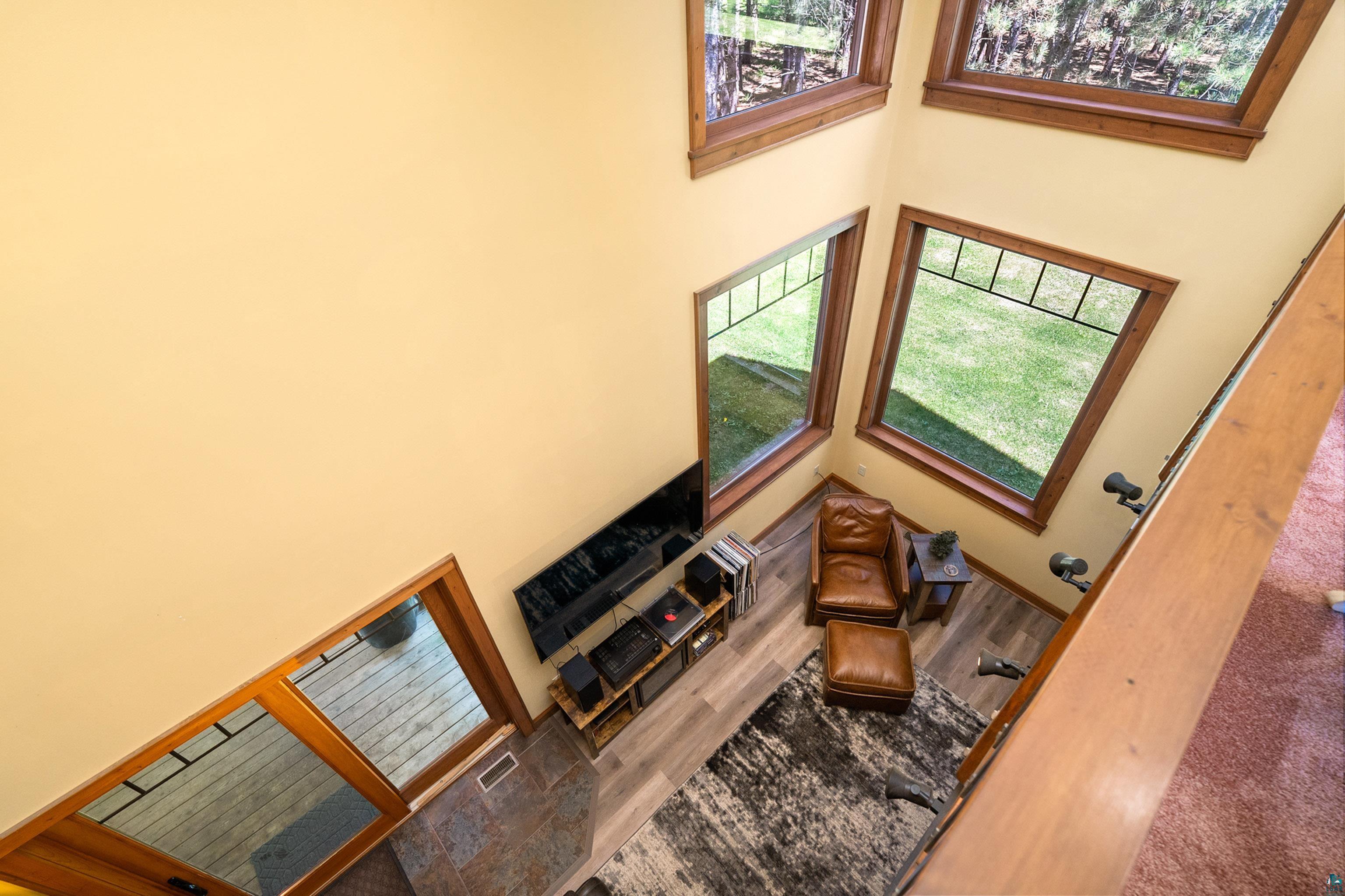 75 East Stark Road Esko, MN 55733 - Photo 29 of 87 Two-story living area featuring wood-finish flooring, a prominent set of multi-level windows with wood trim, and a high ceiling