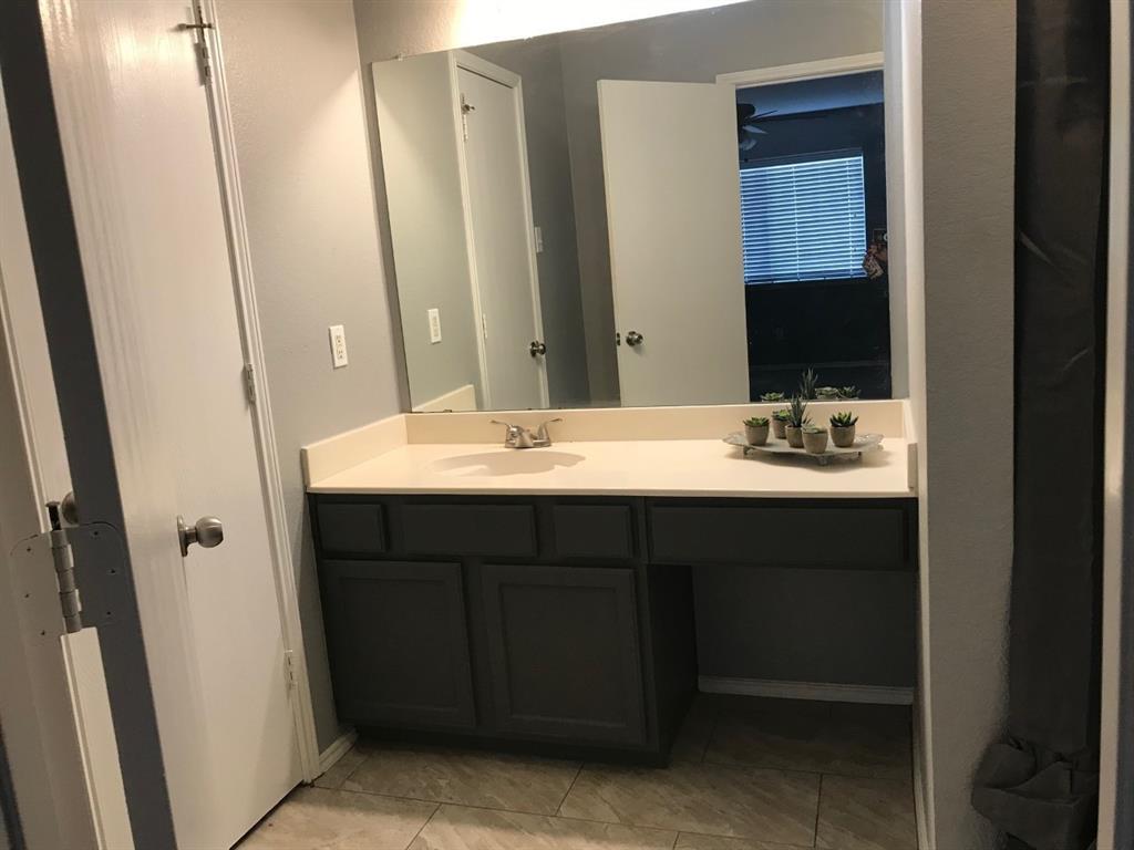 3305 Rustic Meadow Trail Mansfield, TX 76063 - Photo 8 of 12 Bathroom vanity featuring a light-colored countertop, integrated sink, and brushed nickel faucet