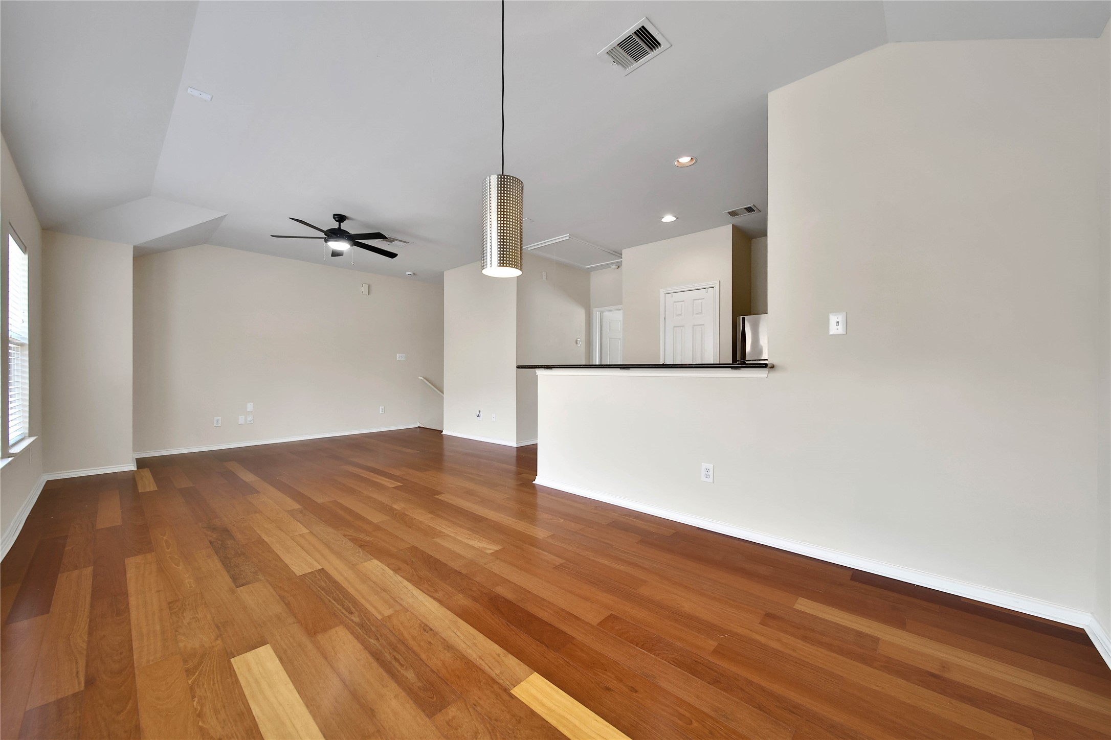 4408 Eigel Street Houston, TX 77007 - Photo 10 of 16 Dining area with modern pendant lighting flows seamlessly into the spacious living room, both accented by rich Brazilian cherry hardwood floors.