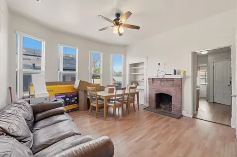 a living room with furniture a fireplace and a floor to ceiling window