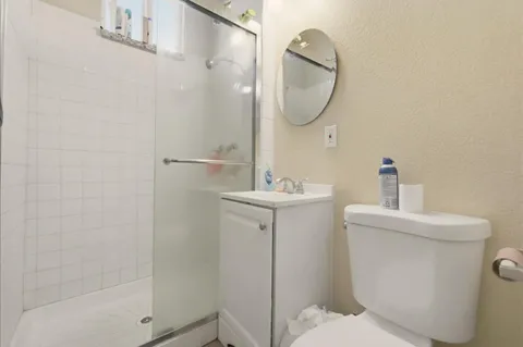 a bathroom with a sink a toilet and shower