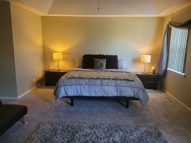 a bedroom with a bed and a night stand