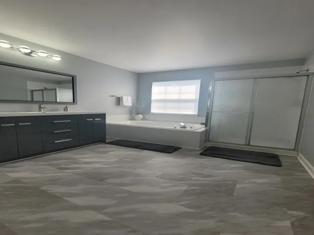a spacious bathroom with a granite countertop sink and a mirror