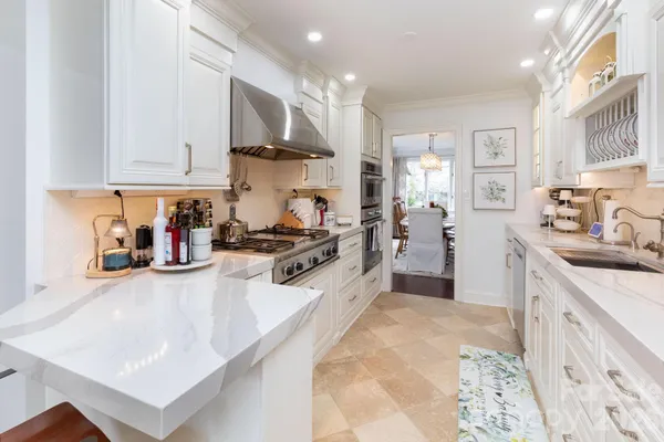 a kitchen with stainless steel appliances granite countertop a sink stove and cabinets