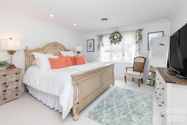a bedroom with a bed flat screen tv and a large window