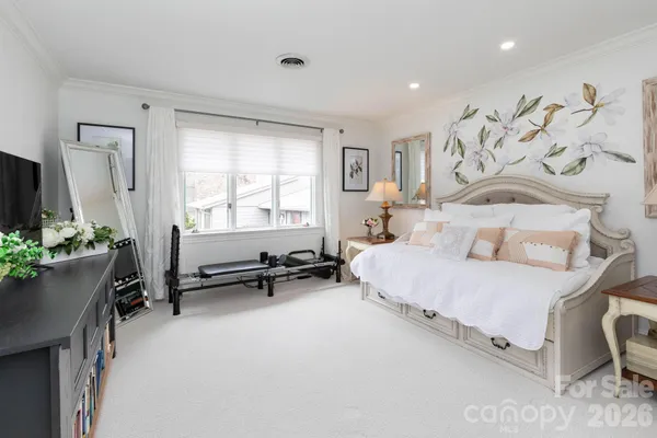 a bedroom with a bed and a chair in it