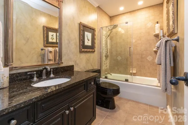 a bathroom with a granite countertop sink mirror and a bathtub