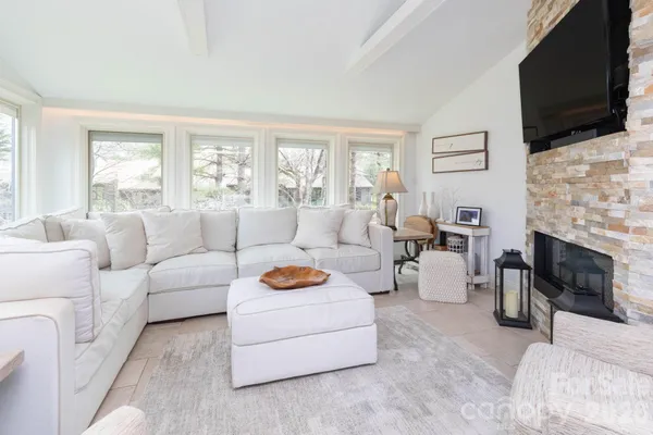 a living room with furniture a flat screen tv and a fireplace