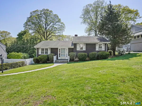 a front view of a house with a yard and trees