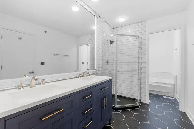 a bathroom with a double vanity sink toilet and shower