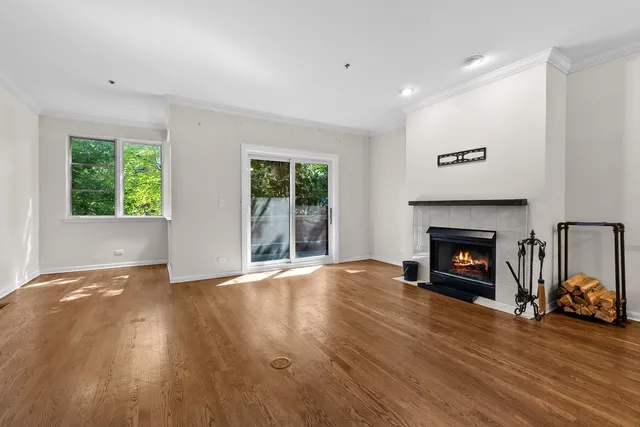 an empty room with floor to ceiling window and fireplace