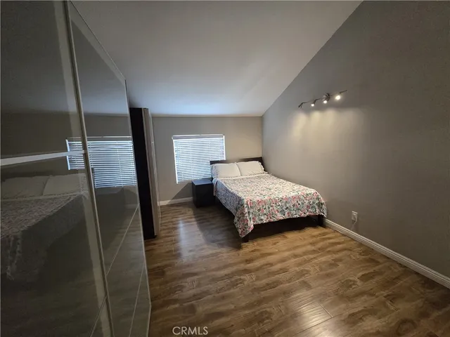 a bedroom with a bed and wooden floor