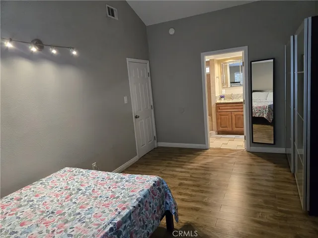 a bedroom with a bed and wooden floor