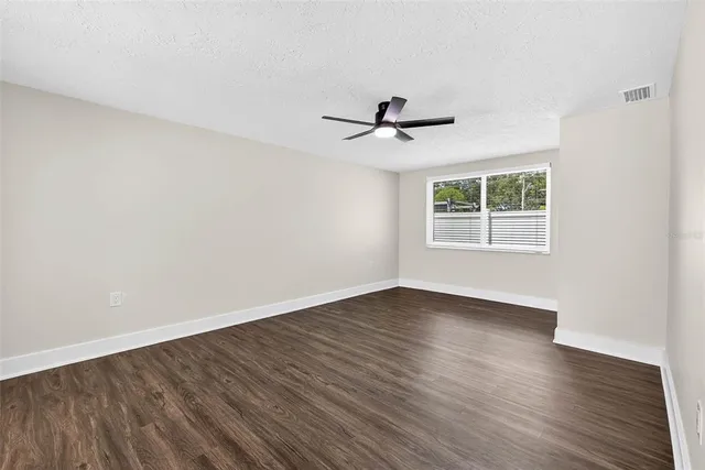 a view of empty room with wooden floor and window