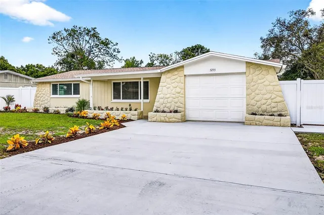 a front view of house with yard and trees in the background