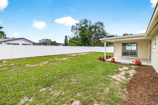 a view of a house with a yard and a patio