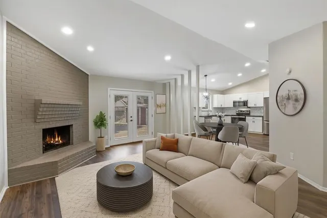 a living room with furniture a fireplace and a floor to ceiling window
