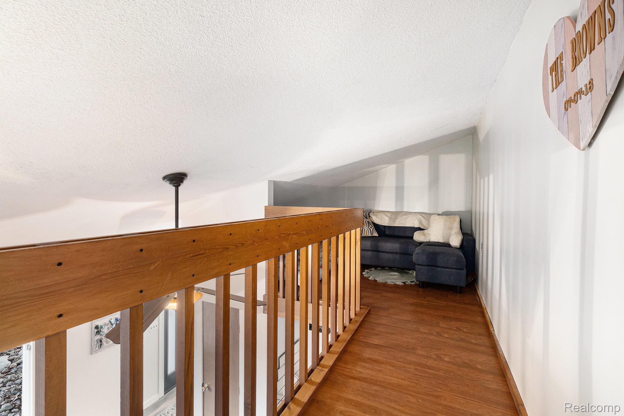 14017 North Belsay Road Millington, MI 48746 - Photo 15 of 43 Hall featuring a textured ceiling, vaulted ceiling, and wood finished floors