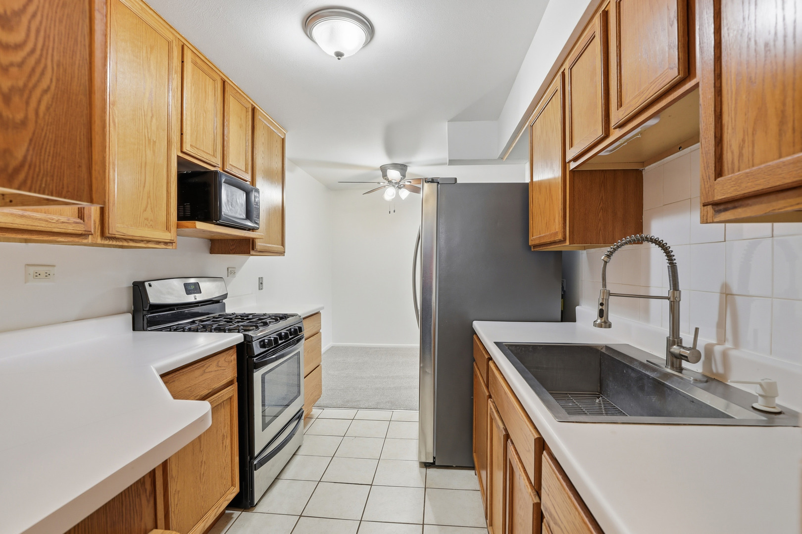 1375 Rebecca Drive, Unit 213 Hoffman Estates, IL 60169 - Photo 9 of 21 a kitchen with stainless steel appliances granite countertop a sink stove and refrigerator