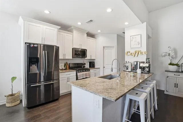 a en suite bathroom with a granite countertop sink and a mirror
