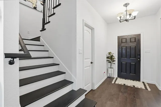 a view of entryway with wooden floor and cabinets