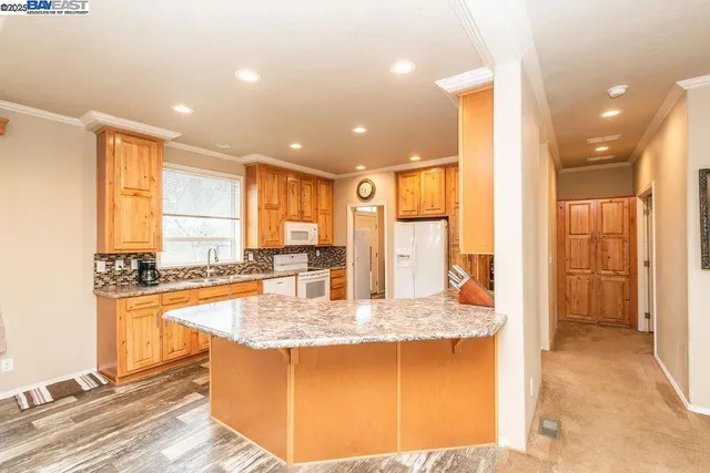 a spacious bathroom with a granite countertop sink and a large mirror next to a window
