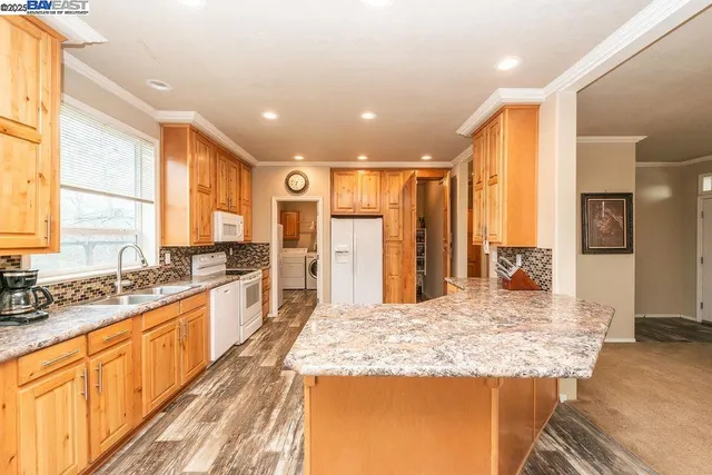 a large kitchen with kitchen island a stove a sink and a refrigerator