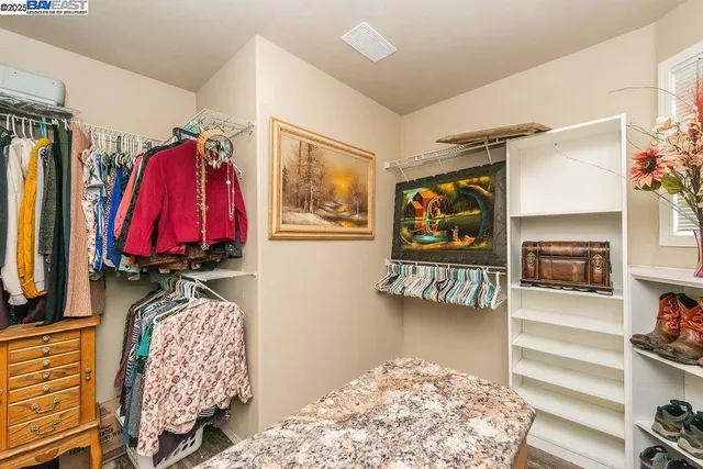 a view of walk in closet with clothes and shoes