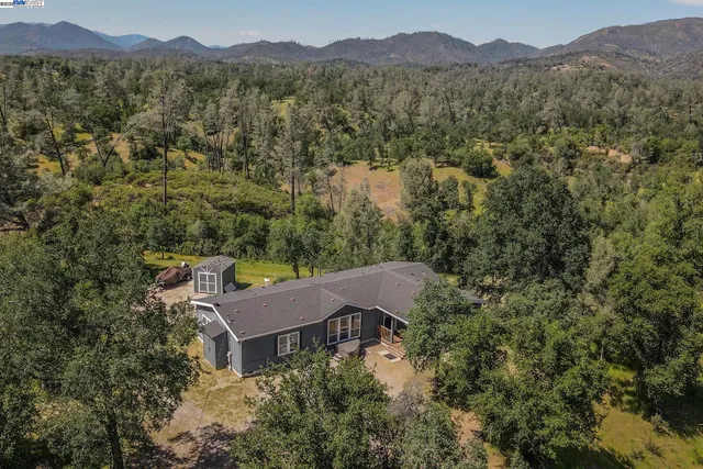 an aerial view of houses with a yard and mountain