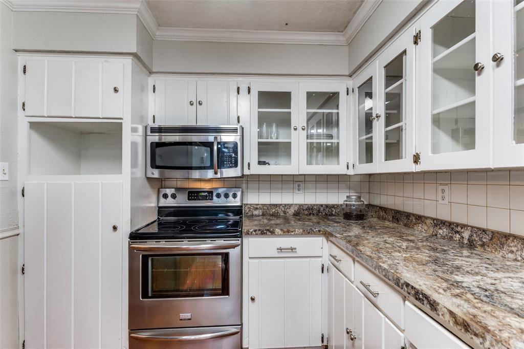 227 North 9th Street Jacksboro, TX 76458 - Photo 7 of 14 a kitchen with stainless steel appliances granite countertop a stove and a microwave