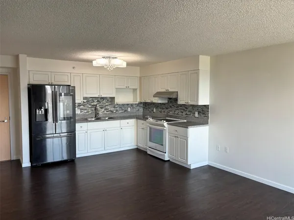 a kitchen with granite countertop white cabinets and stainless steel appliances