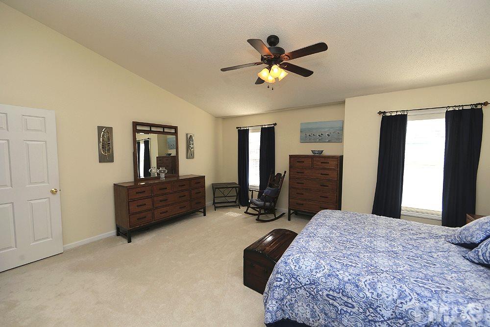 8313 Trumpetor Way Raleigh, NC 27613 - Photo 12 of 21 a bedroom with a bed a ceiling fan and a dresser