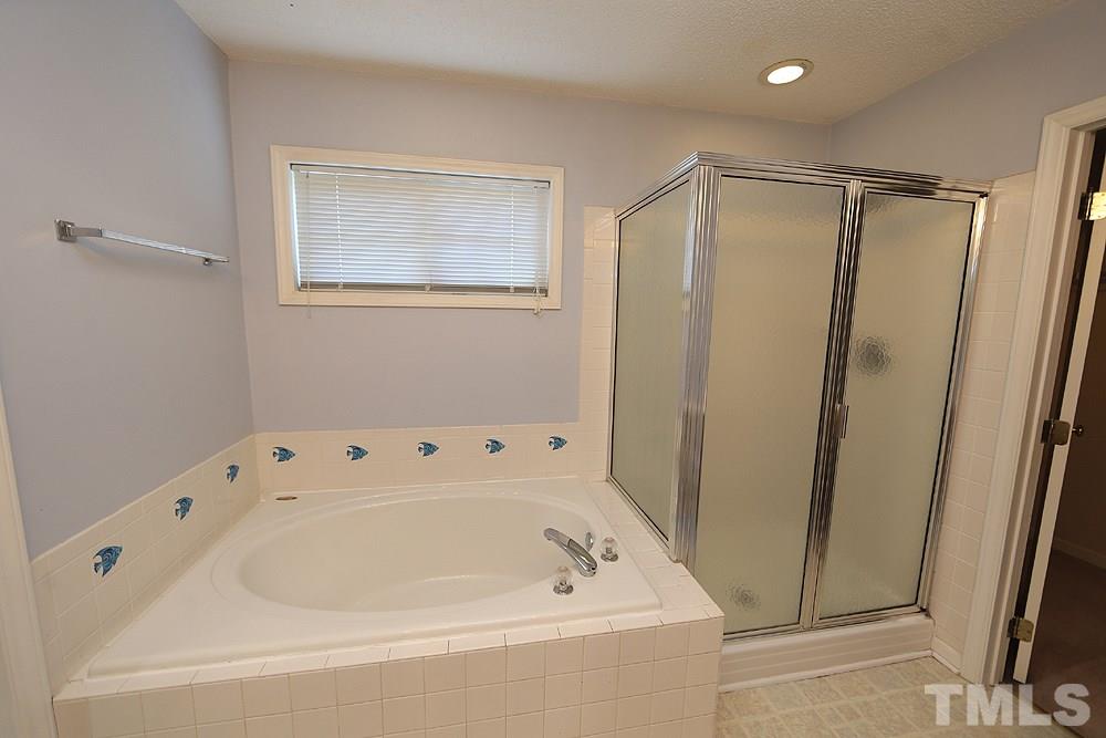 8313 Trumpetor Way Raleigh, NC 27613 - Photo 14 of 21 a white bath tub sitting next to a shower