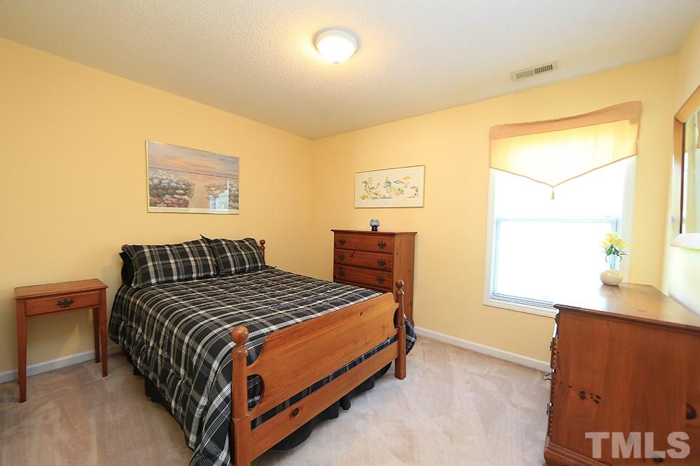 8313 Trumpetor Way Raleigh, NC 27613 - Photo 15 of 21 a bedroom with a bed and a window