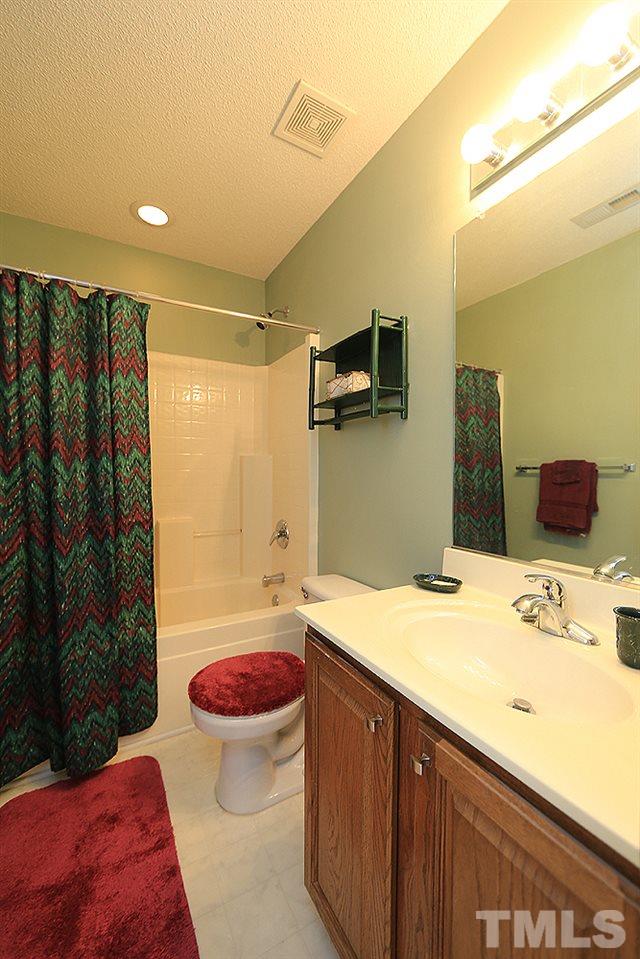 8313 Trumpetor Way Raleigh, NC 27613 - Photo 17 of 21 a bathroom with a sink a toilet and shower