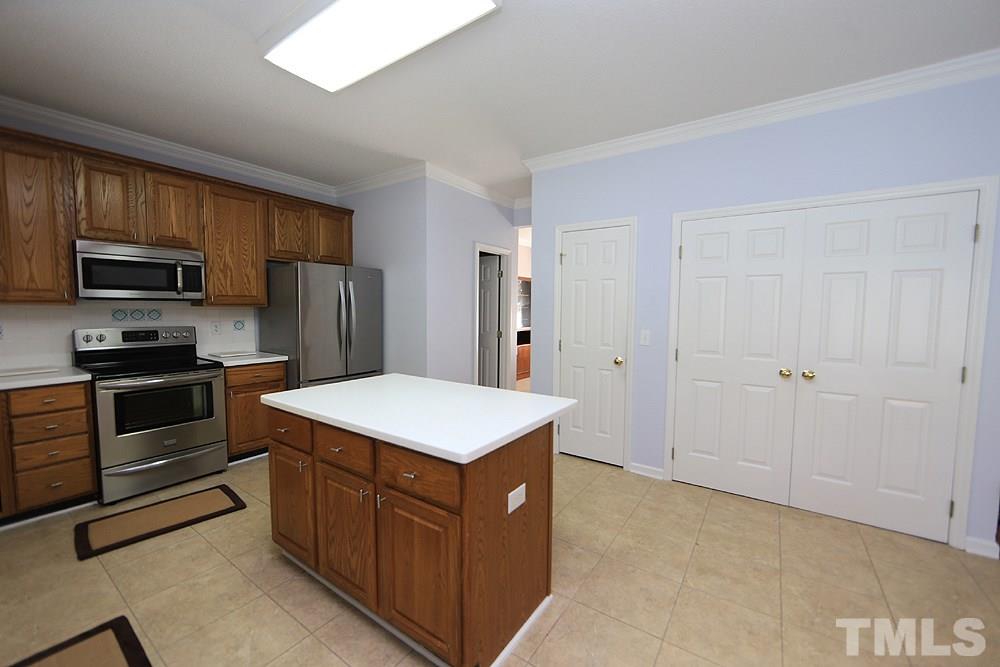 8313 Trumpetor Way Raleigh, NC 27613 - Photo 10 of 21 a kitchen with stainless steel appliances a refrigerator and a stove top oven