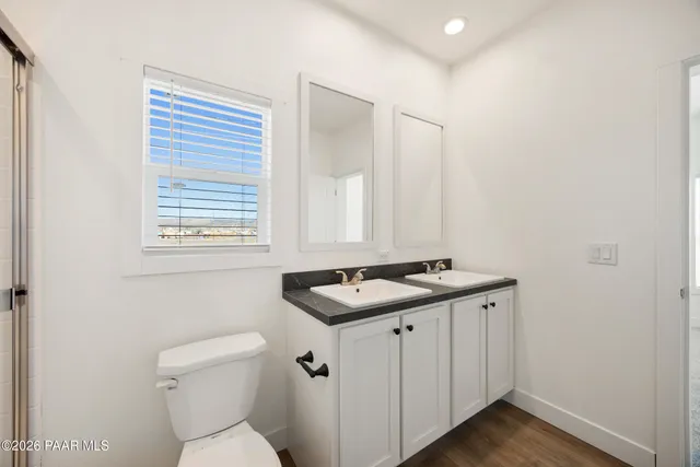 a bathroom with a granite countertop sink toilet and mirror