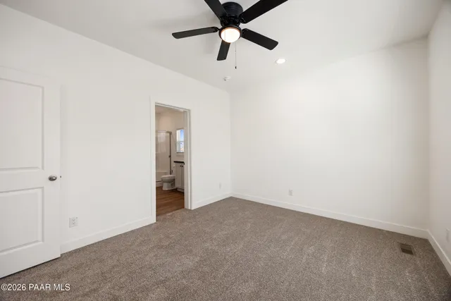 an empty room with chandelier fan