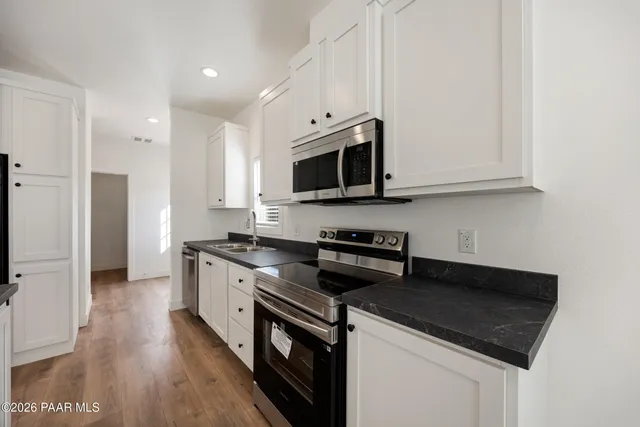 a kitchen with stainless steel appliances a stove a microwave a sink and cabinets
