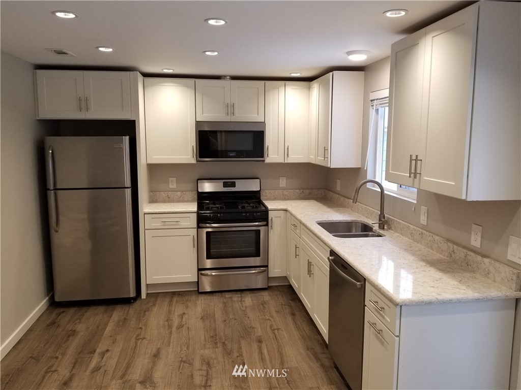 3436 Southeast 5th Street Renton, WA 98058 - Photo 6 of 28 a kitchen with a sink a refrigerator and a stove top oven