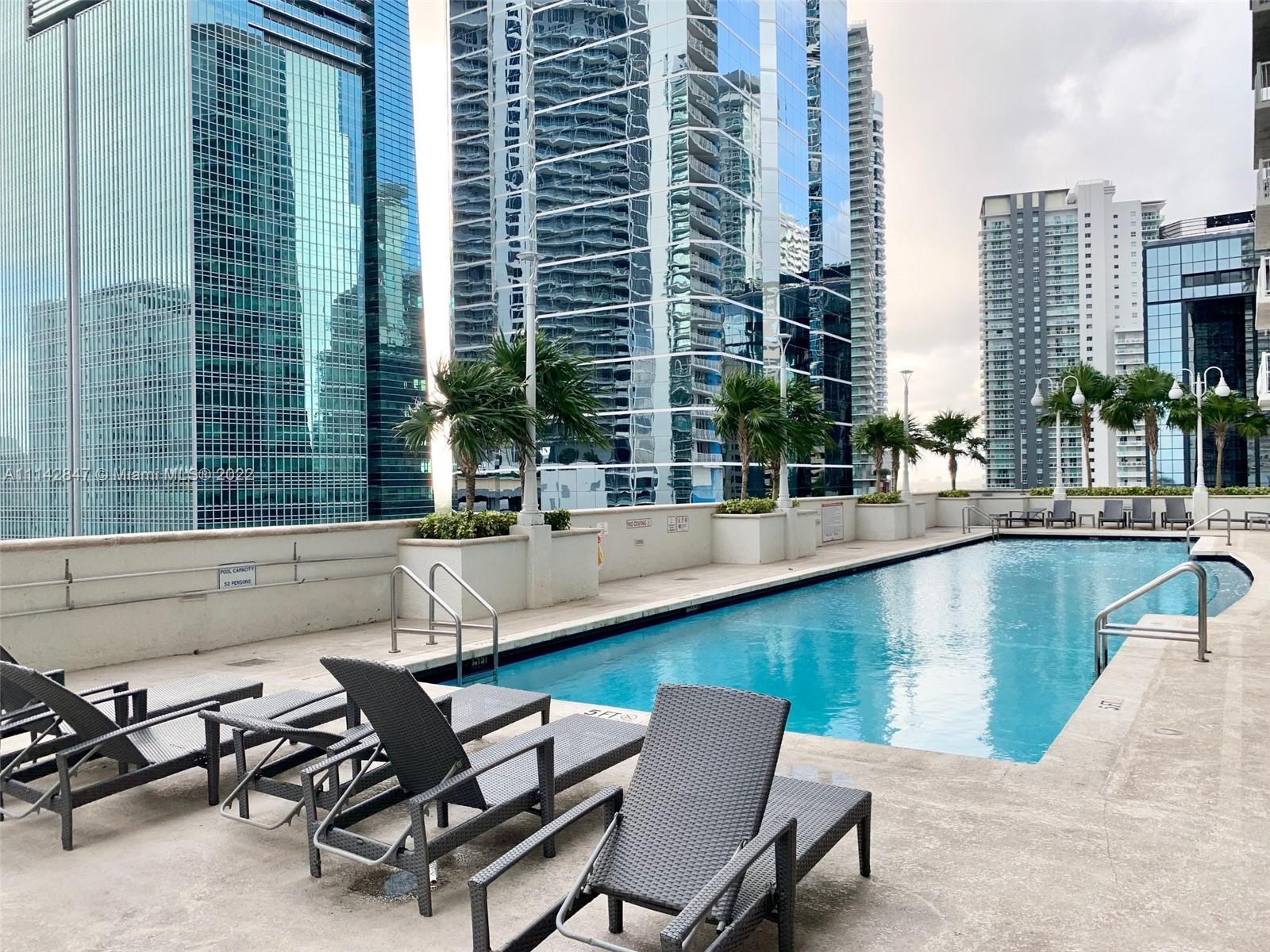 1200 Brickell Bay Drive, Unit 1812 Miami, FL 33131 - Photo 15 of 24 a view of a swimming pool with chairs