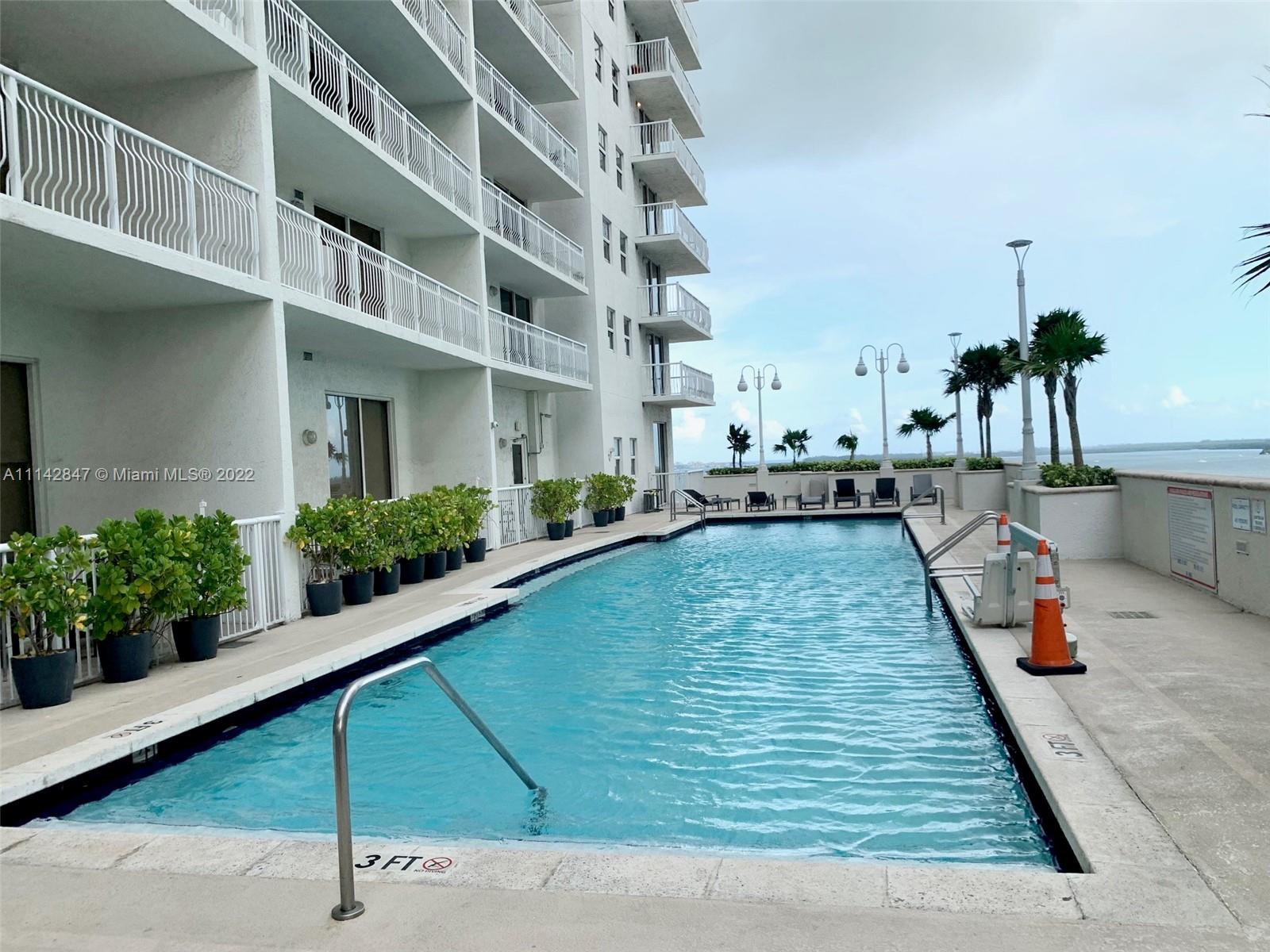 1200 Brickell Bay Drive, Unit 1812 Miami, FL 33131 - Photo 17 of 24 a swimming pool with outdoor seating and yard