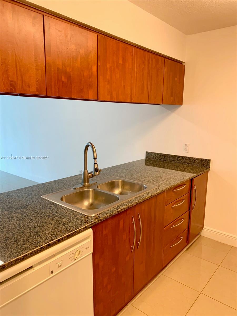 1200 Brickell Bay Drive, Unit 1812 Miami, FL 33131 - Photo 3 of 24 a kitchen with granite countertop sink and cabinets