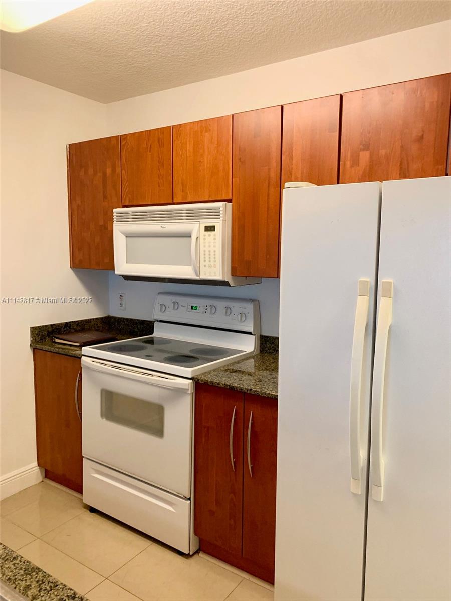 1200 Brickell Bay Drive, Unit 1812 Miami, FL 33131 - Photo 4 of 24 a kitchen with a stove and a refrigerator