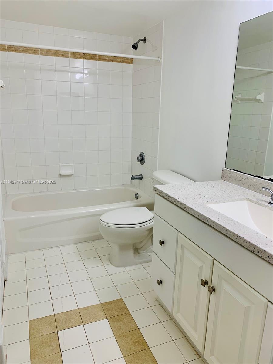 1200 Brickell Bay Drive, Unit 1812 Miami, FL 33131 - Photo 10 of 24 a bathroom with a granite countertop toilet a sink and shower