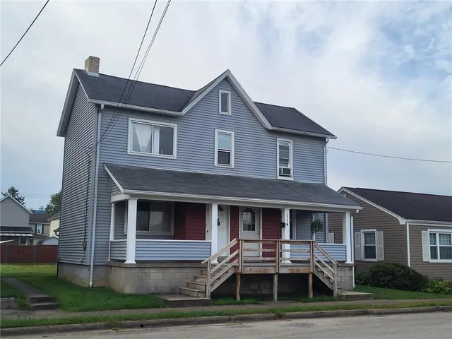 a front view of a house with yard and parking space