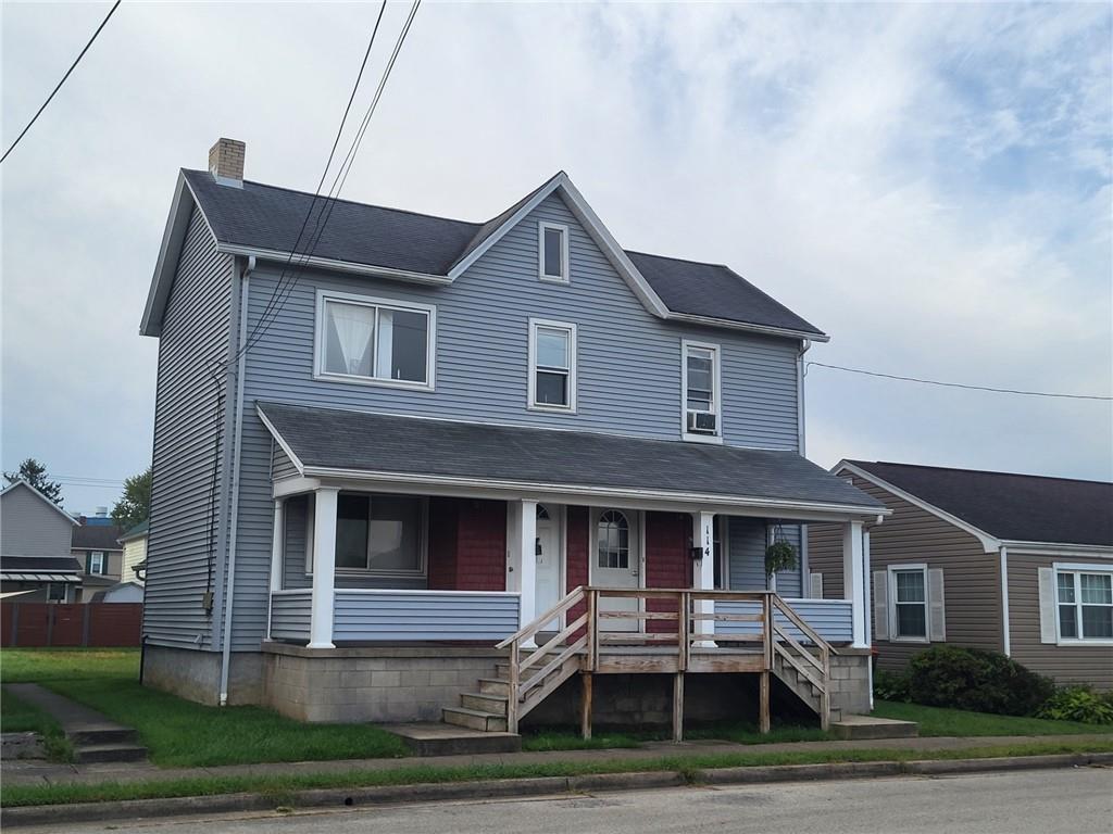 a front view of a house with yard and parking space