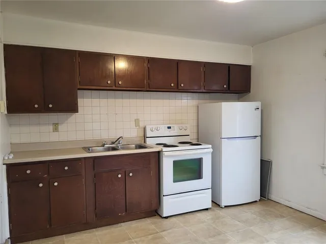 a kitchen with a sink a stove and cabinets